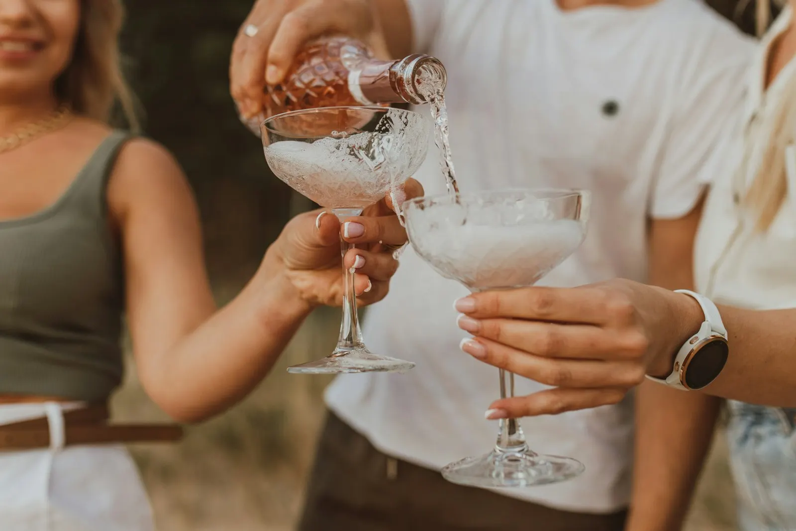 Friends holding wine glasses together outdoors