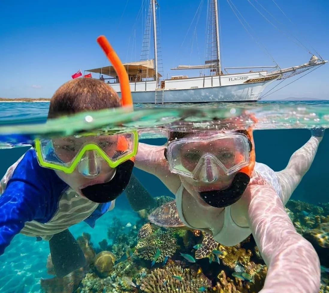 A snorkeler smiles at the camera in clear turquoise water off Aruba's coast