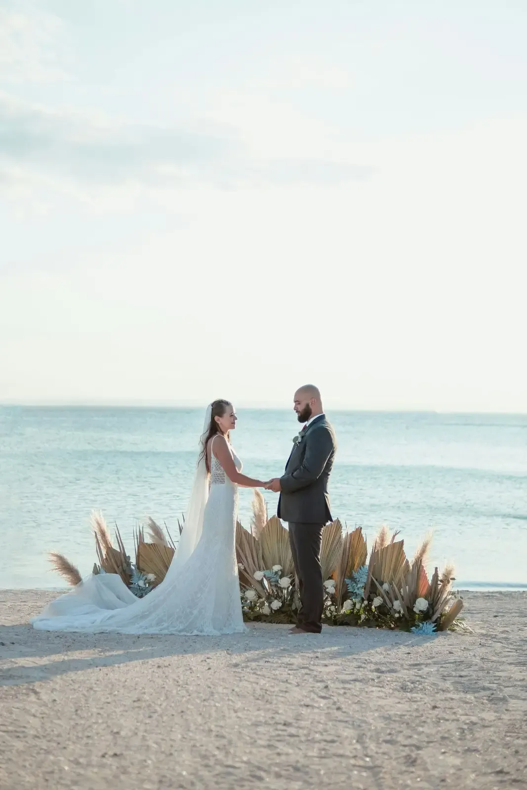 A bride and groom holding hands on an Aruba beach
