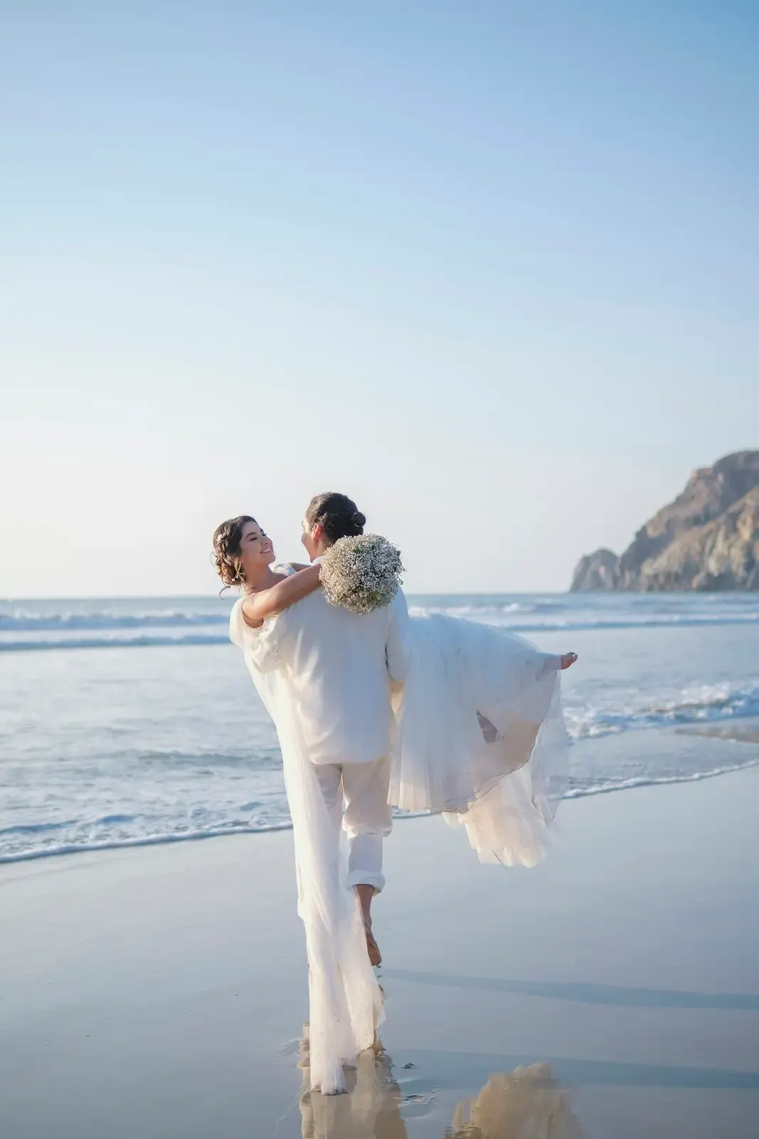 A man and a woman holding hands on an Aruba beach