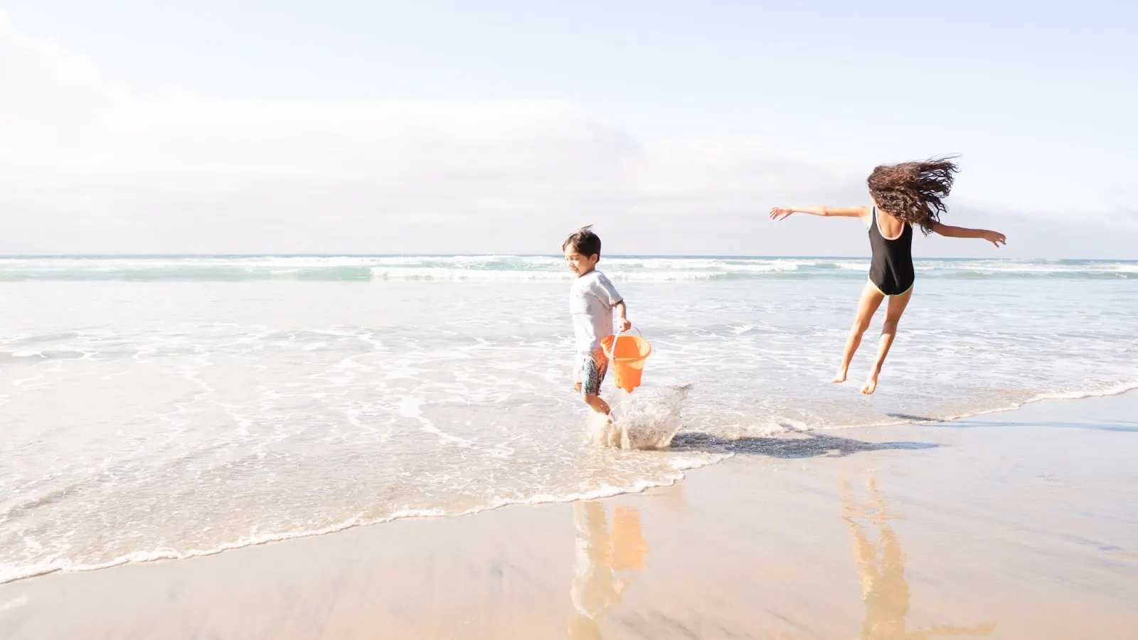 Two boys running together on an Aruba beach