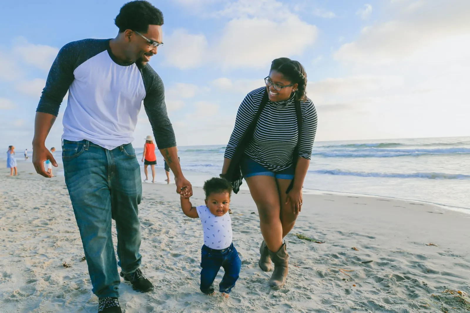 An adult holding a baby on an Aruba beach