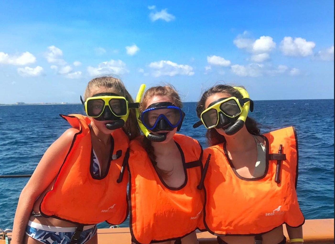 Guests wearing snorkel masks and life vests in the clear water off Aruba